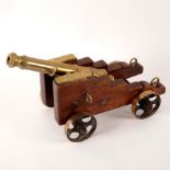 A tabletop model of a brass cannon with moulded muzzle and ring decoration,