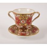 A Derby two-handled cup and saucer, circa 1820, enamelled in red, green and gilt with flowerheads,