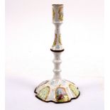 A Bilston enamel candlestick with baluster column enamelled reserves, decorated pastoral scenes, 26.
