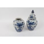 A pair of Dutch Delft jars, one with cover, each of lobed form decorated a landscape with birds,