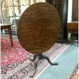 An 18th Century walnut circular tilt-top table, turned column and tripod support,