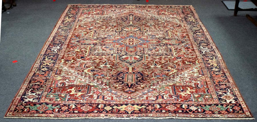 A Persian Heriz carpet, early 20th Century, of geometric design within a multiple border,