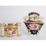 An English porcelain spill vase/card rack of castle form painted panels of flowers and a Coalport