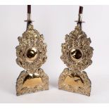 A pair of plated Carolean style silhouette candlesticks embossed c scrolls and acanthus,