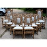 A set of fourteen 17th Century style bleached oak, heavily carved dining chairs,