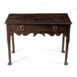 A 18th Century oak side table fitted a drawer with carved front and raised on round legs with pad