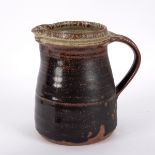 Richard Batterham (born 1936), a ribbed stoneware jug, tenmoku glaze to an ash glaze rim, 16.