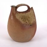 A Studio Pottery vessel, earthenware with dripped celadon glaze to the top, curved handle and spout,