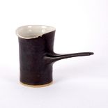 Lucie Rie (1902-1995), a milk jug, with manganese glaze and cream interior, elongated handle,