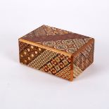 A Japanese twenty step puzzle box, decorated intricate patterns and designs,