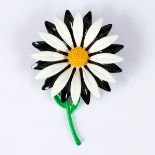 A 1960s style enamelled brooch in the form of a stylised daisy,
