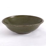 A Studio Pottery bowl with dark green glaze and speckled rim, indistinct mark to base, 26.