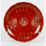 A Red ground lobbed dish, decorated with poems and flowers