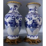 (lot of 2) A pair of Chinese blue and white vases, each with gilded mouth rim on a metal stand, 17"