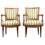 Pair of Neoclassical style fauteuils, each having striped upholstery and rising on turned and