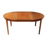 A Danish Modern dining table, having a circular top with (3) 20"l leaves, and rising on tapered