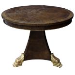 An Empire style walnut center table, having a circular top above a tripod base terminating on gilt