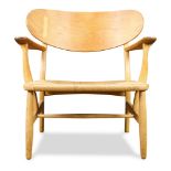 Danish Modern Hans Wegner CH-22 Easy chair, having a shaped back above a rush seat, and rising on