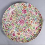 A Chinese large famille-Rose enameled "Mille Fleurs" charger, with rounded sides painted on the