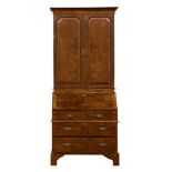 A George I style walnut bureau bookcase, the superstructure with two panelled doors having burl