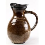 A Pond Farm stoneware pitcher, having a shaped rim with spout above a handled body having a