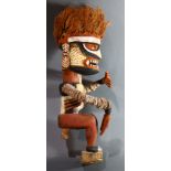 A Malanggan carved wood figure with orange raffia hair, colorfully decorated with hands and