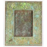 A Tiffany Studios Pine Needle pattern picture frame, executed in patinated bronze with green slag