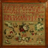 Framed needlework sampler, having floral reserves surmounted by the alphabet in different fonts, and