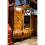 Continental bombe form armoire, the inlaid three door case with marquetry detail centered with the