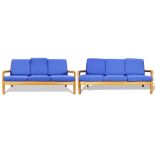 A pair of Mid-Century Modern sofas, each having three seats with cobalt blue cushions, continuing to