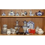 Two shelves with Russian blue and white table articles including two miniature ceramic samovars, a