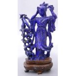 A Chinese lapis lazuli figure of beauty looking at a mirror, with a carved wood stand, size