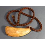 A Tambua whale tooth with necklace of woven fiber