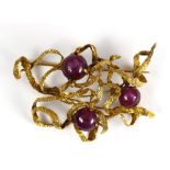 Ruby and 10k yellow gold brooch Featuring (3) round ruby cabochons, measuring approximately 9.90 mm,