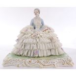 Italian Capodimonte style crinoline figural sculpture depicting a young lady, grasping sheet