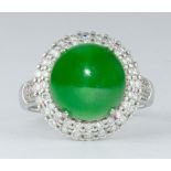 Jadeite, diamond, 18k white gold ring Centering (1) round, jadeite cabochon, accompanied by a