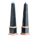 (lot of 2) Neoclassical style variegated marble obelisks, executed in black, accented with rose