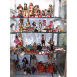 Four shelves of worldwide dolls