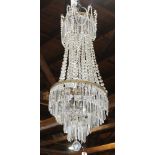 Crystal chandelier, the large form having cascading crystal drops continuing to the graduated
