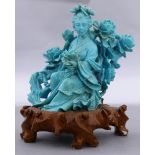 A carved Chinese turquoise figure of seated lady holding lotus flowers, size without stand 4.75"h.