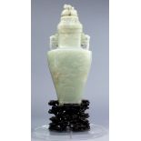 A Chinese nephrite jade lidded vase, the cap with carved double peach finial to the top, carved with