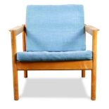 Danish Modern armchair, having original blue cushions centering the teak frame, and rising on turned