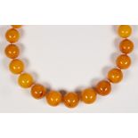 Amber bead, silver, metal necklace Composed of (23) round, butterscotch amber beads, ranging in size