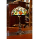 Tiffany style leaded glass lamp, having a floral decorated shade and rising on a patinated base,