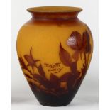 An Andre Delatte Nancy cameo glass vase, having a tapered form executed in maroon cut to amber,