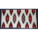 A Southwest American Indian Navajo textile, mid-20th Century, with dark brown and bright red