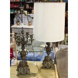 Pair of Rococo style candelabra lamps, each having a double light socket above four scrolled arms,