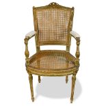 Louis XVI style fauteuil, having a carved crest, above a cane back, continuing to an upholstered