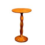 Contemporary maple side table, the circular plank top on a baluster standard resting on a circular