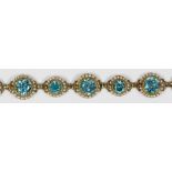 Blue zircon, seed pearl, 14k yellow gold bracelet Featuring (12) round-cut blue zircons, weighing